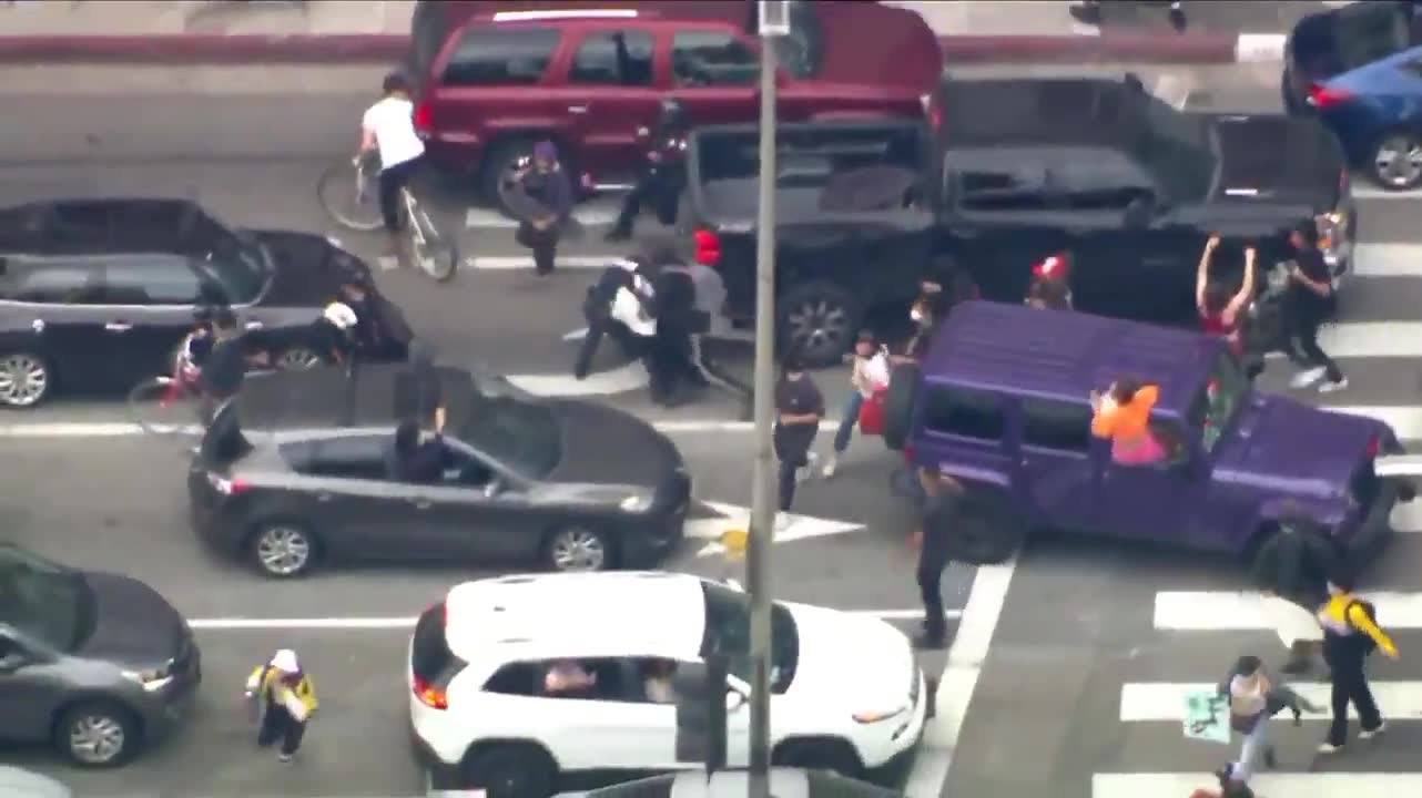 LAPD officer trying to arrest someone surrounded by protesters...
